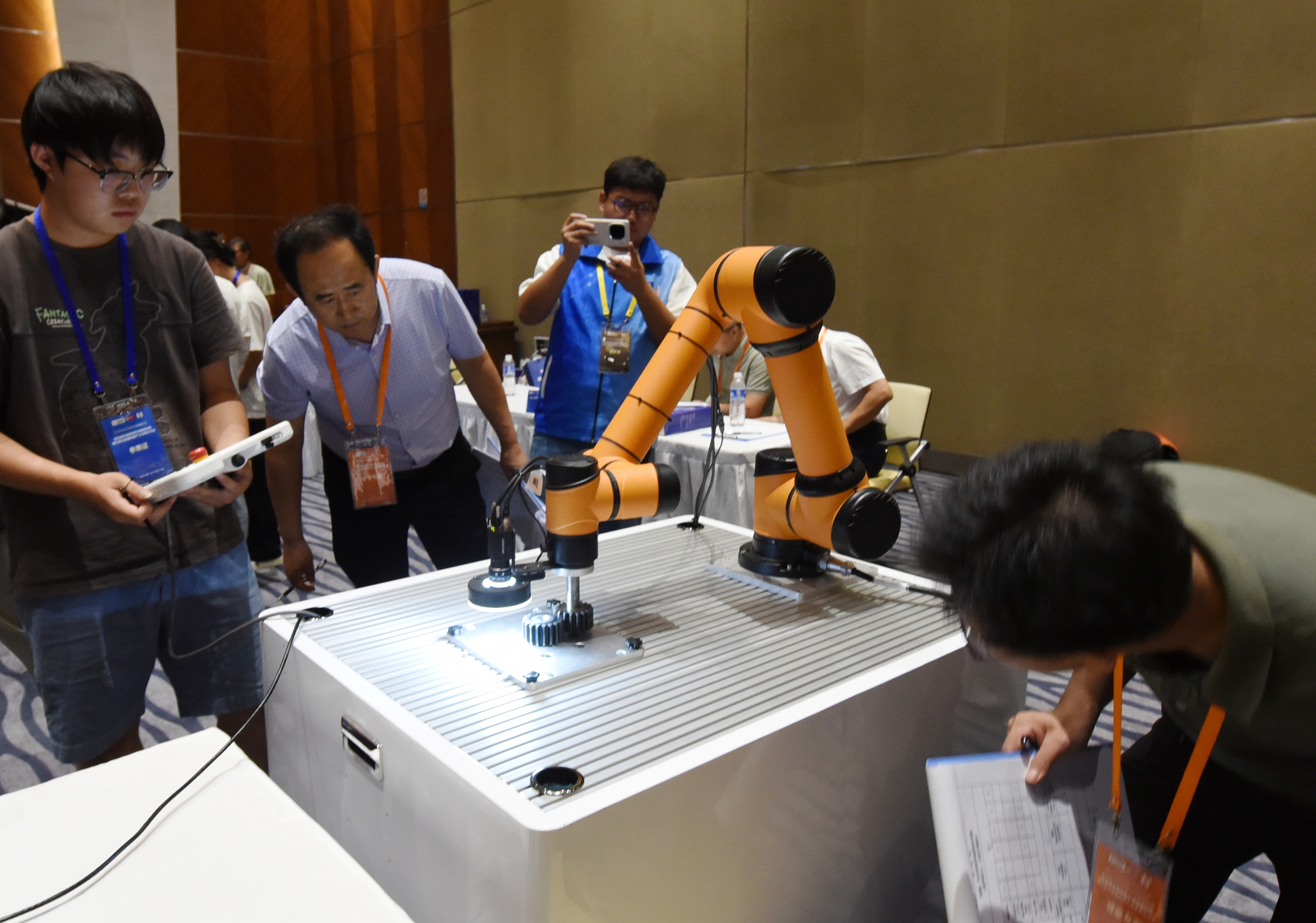 2025年中國(guó)大學(xué)生機(jī)械工程創(chuàng)新創(chuàng)意大賽智能精密裝配賽京津冀魯聯(lián)賽現(xiàn)場(chǎng)，評(píng)委對(duì)參賽選手進(jìn)行實(shí)操調(diào)試評(píng)比。